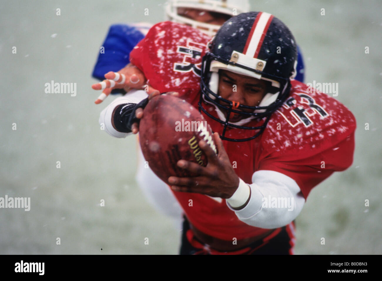 American football player reaching for the ball Stock Photo - Alamy