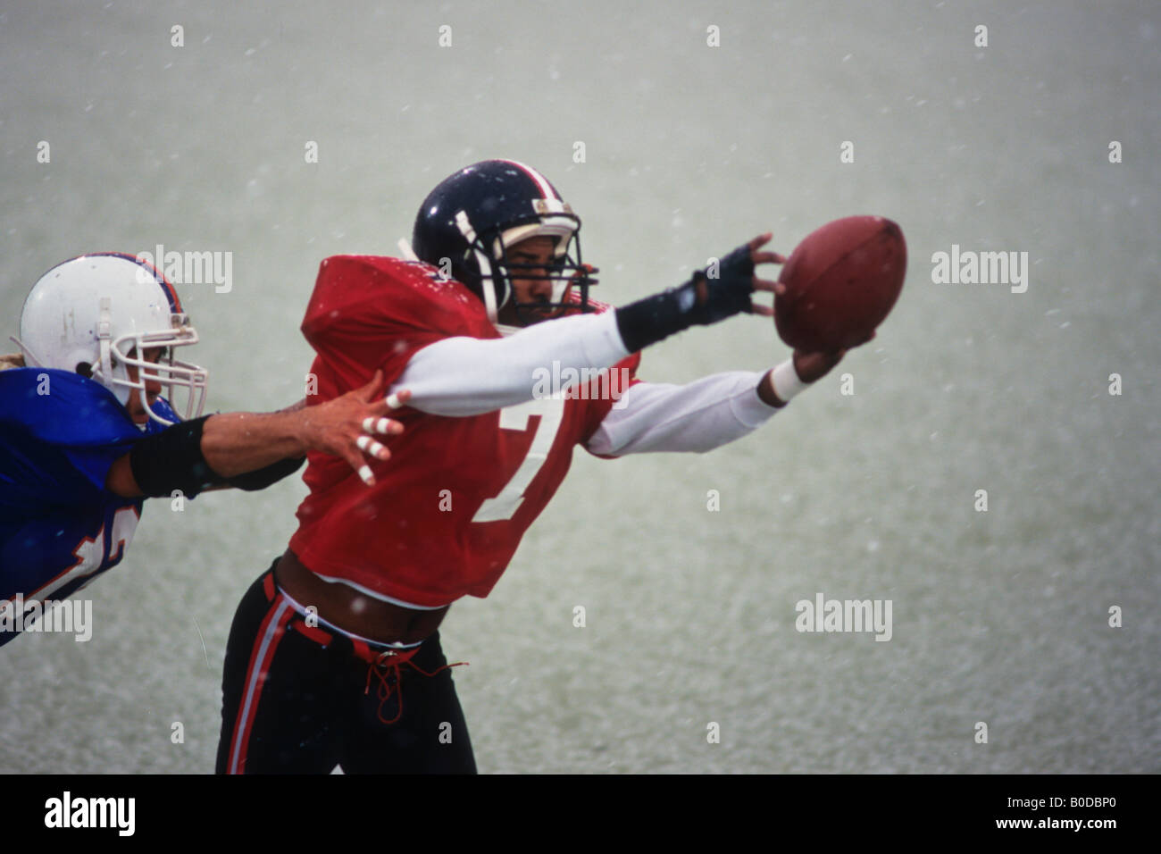 American football player reaching for the ball Stock Photo - Alamy