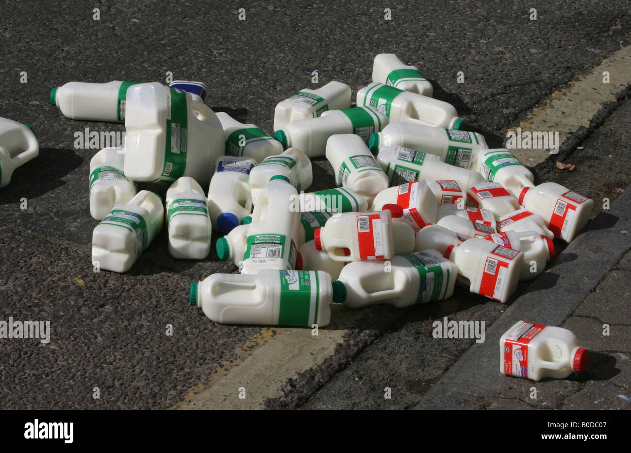 Pints of spilt milk on a pavement await to be cleared by the milkman in