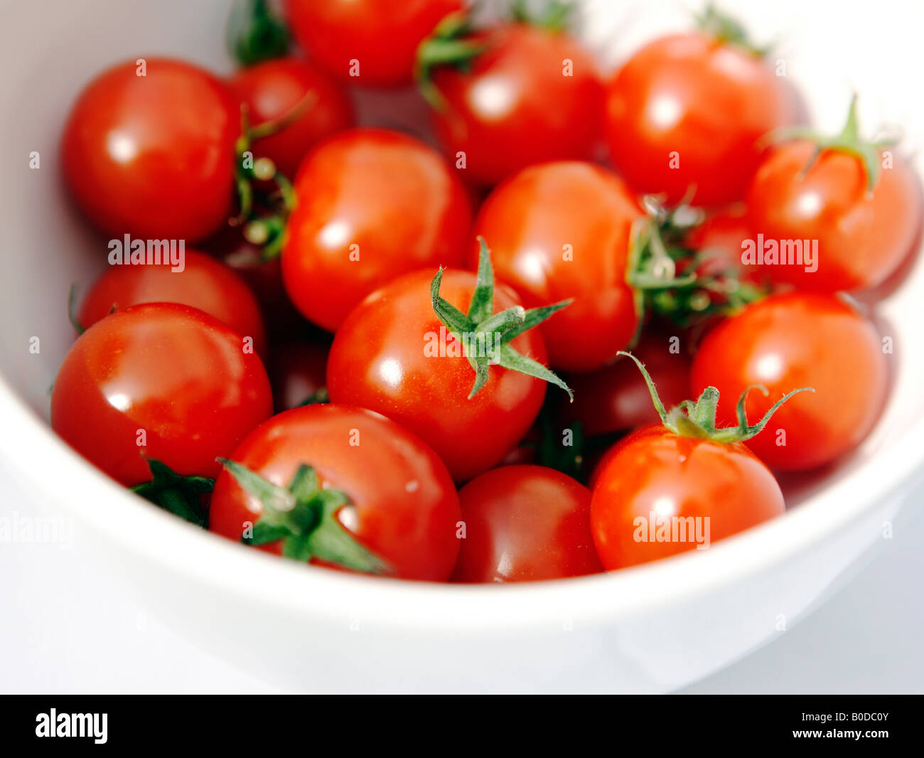 Small white bowl full of cherry tomatoes at a summer barbeque Stock Photo