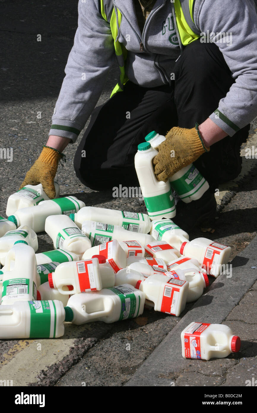 Pints of spilt milk on a pavement are cleared by the milkman in Tetbury