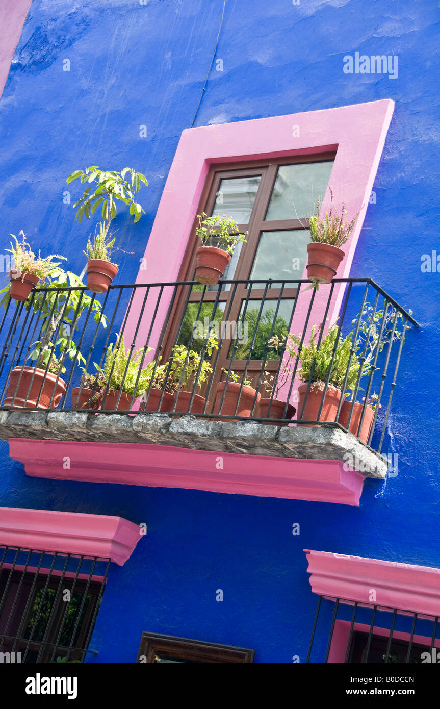 Lurid bright paint work on house wall and window frame. Typical Mexican style of garish pink and blue colour scheme. Stock Photo