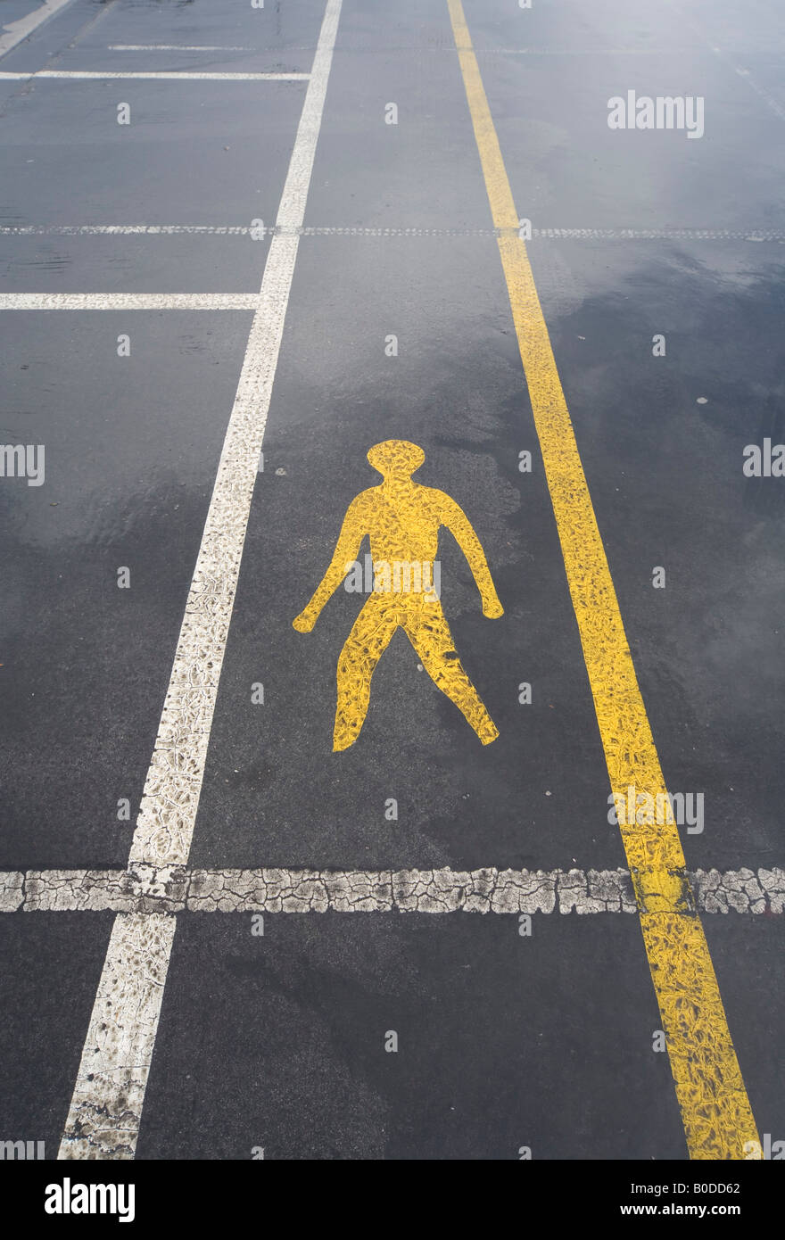 Road Marking of human figure showing pedestrian walkway through car park Stock Photo