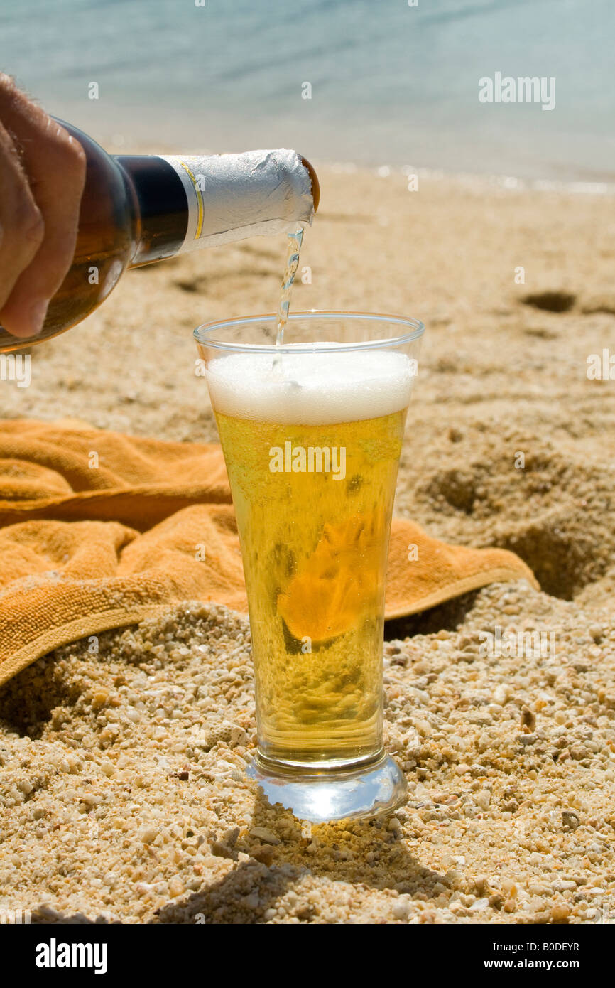 Beer being poured into a glass on a beach Koh Samui, Thailand Stock