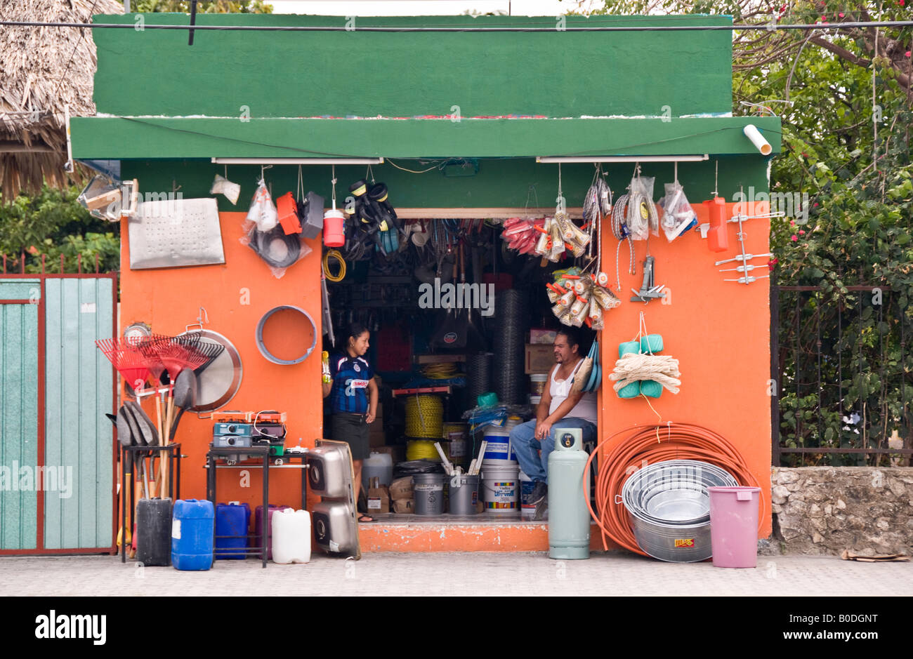 Bright orange coloured hardware shop Tulum, Mexico. Selling tubing, galvanised buckets, paraffin, rakes, gas, spades, rope Stock Photo