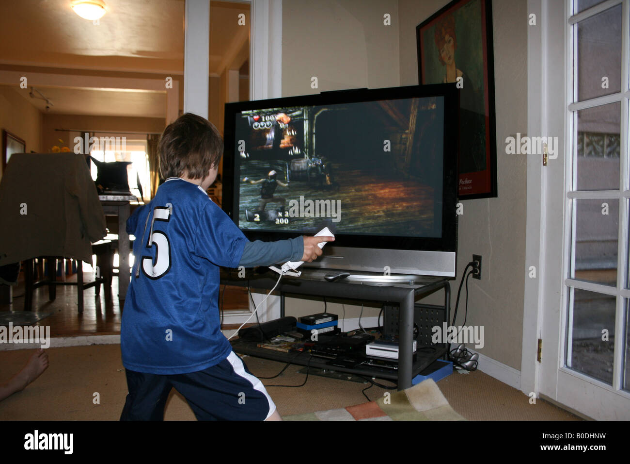 five year old child playing wii video game at home with large flat screen tv, pirate battle Stock Photo