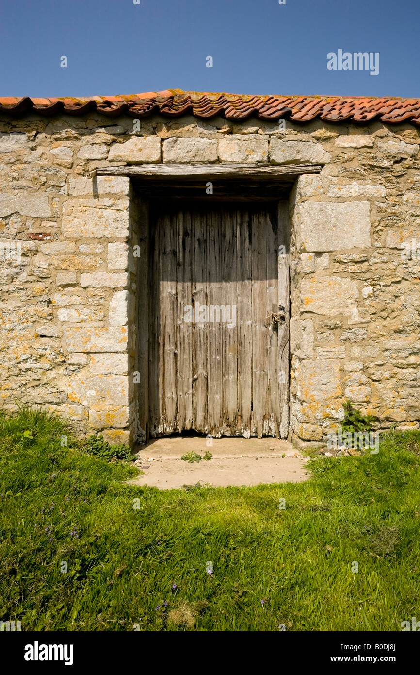 Rustic, weathered wooden door in stone wall Stock Photo - Alamy