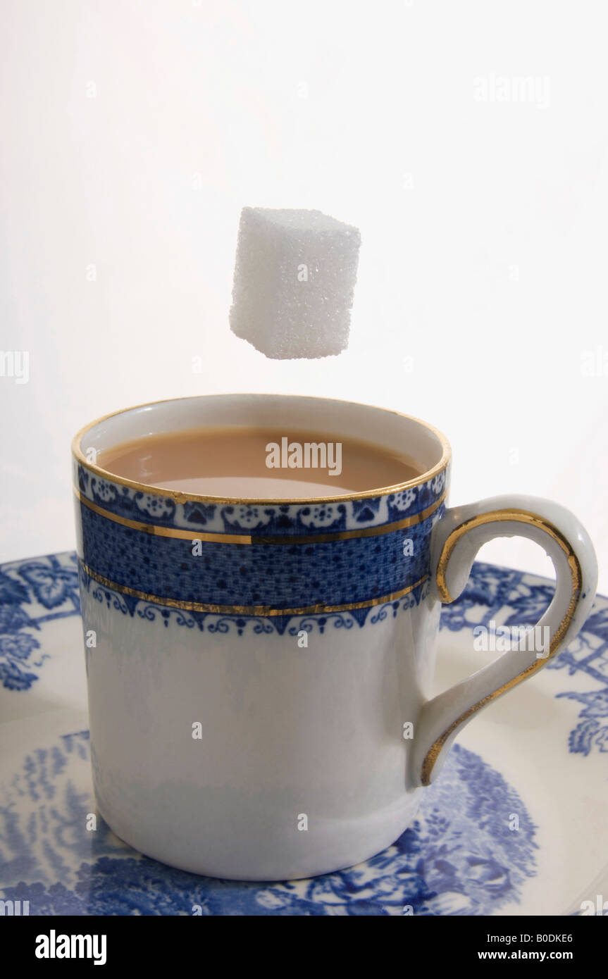Sugar cube falling in tea cup Stock Photo