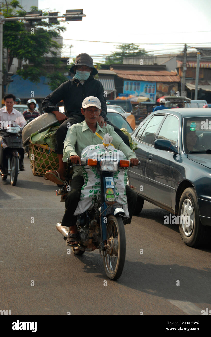people on the street, riding overloaded motorbikes,   phnom penh, cambodia Stock Photo