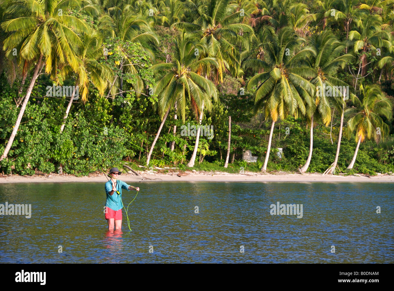 A woman fly fishing in tropical paradise in the caribbean ocean off of