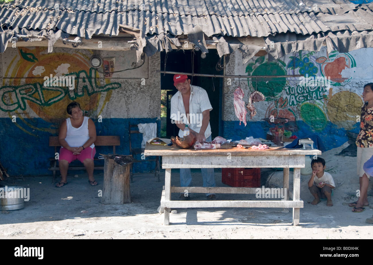 Road-side butcher's shop near Merida, Mexico. The mother, wife and son stand by whilst the father hacks up the meat outside. Stock Photo