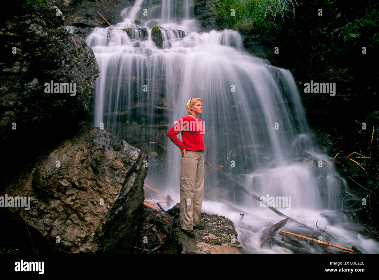 A hiker stands near a waterfall a few miles from the town of Vail Stock Photo