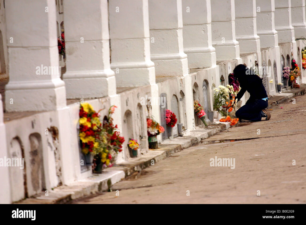 Bogota Central Cemetery, woman visiting a grave and praying Stock Photo