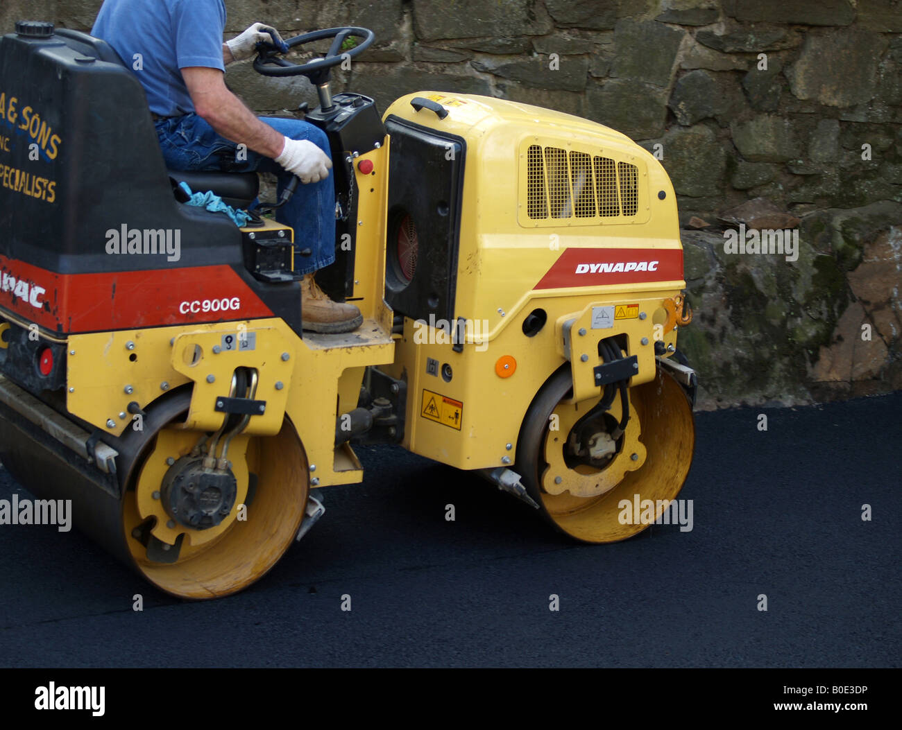 Asphalt Rool Work Workman rolls fresh asphalt on newly constructed driveway Stock Photo ...