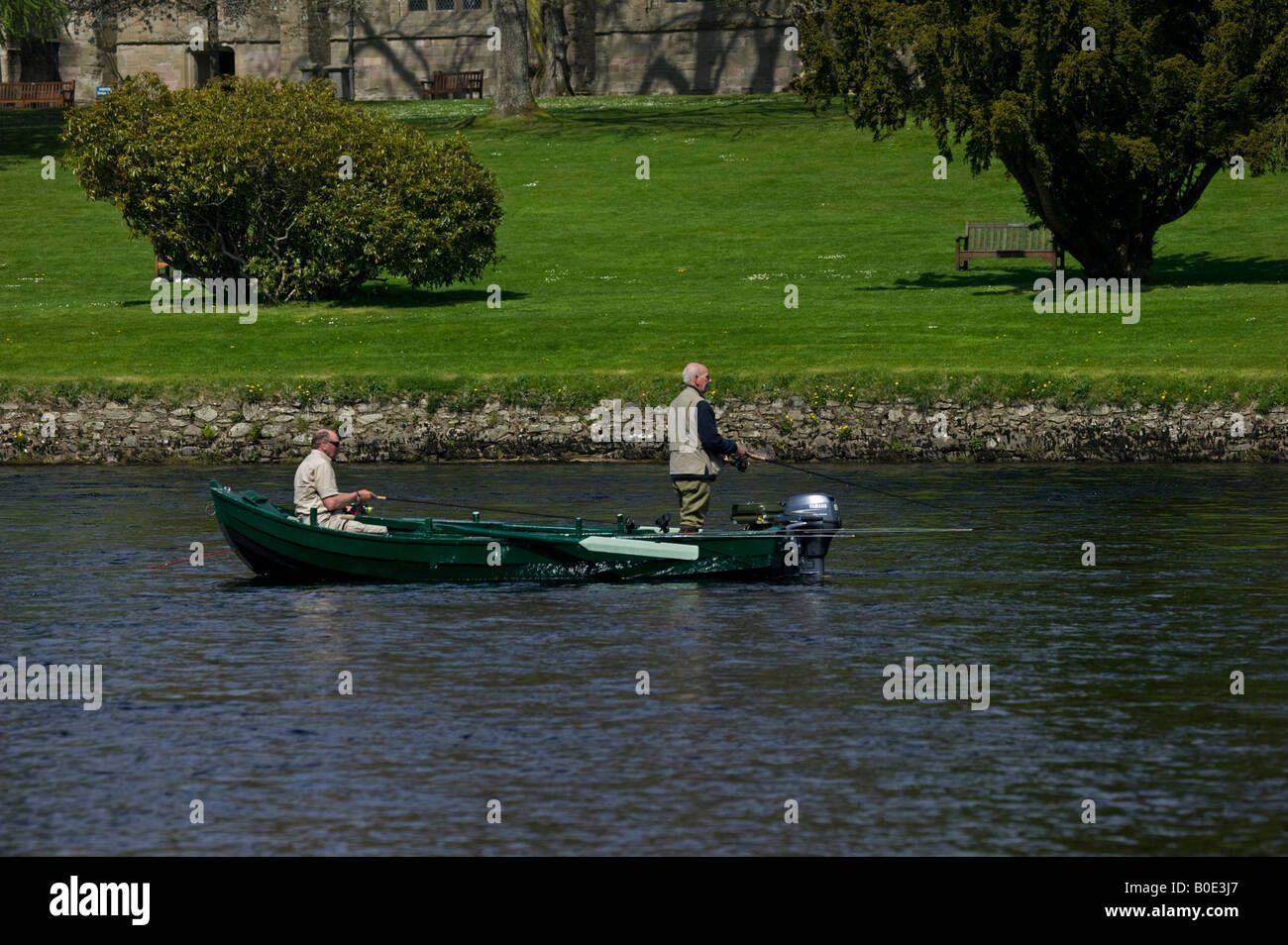 Two men fishing from inflatable boat on river Stock Photo