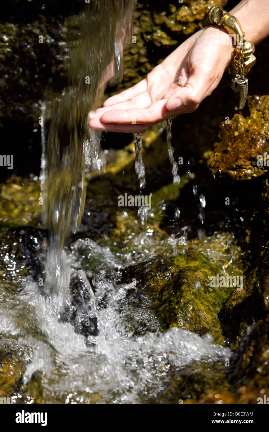 Spring water cascading off rock woman's wet hand, ornamental water feature, Mijas Pueblo, Costa del Sol, Andalucia, Spain Stock Photo