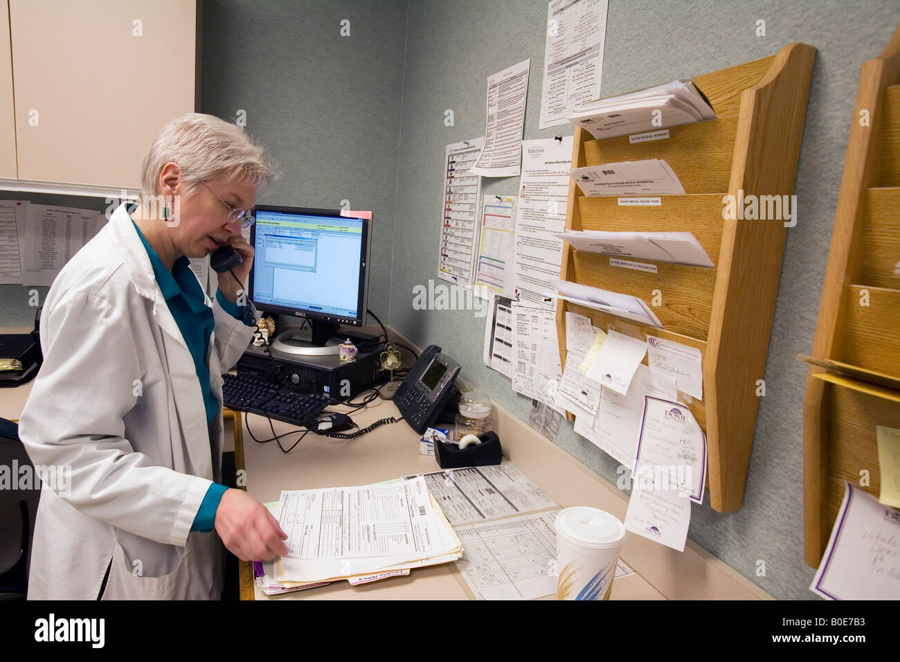 Research nurse checks on results of blood tests for patient participating in clinical trial of new cancer treatment Stock Photo