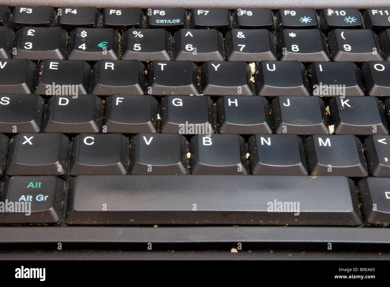 A dirty computer keyboard with crumbs of food between the keys harbouring harmful bacteria. Stock Photo