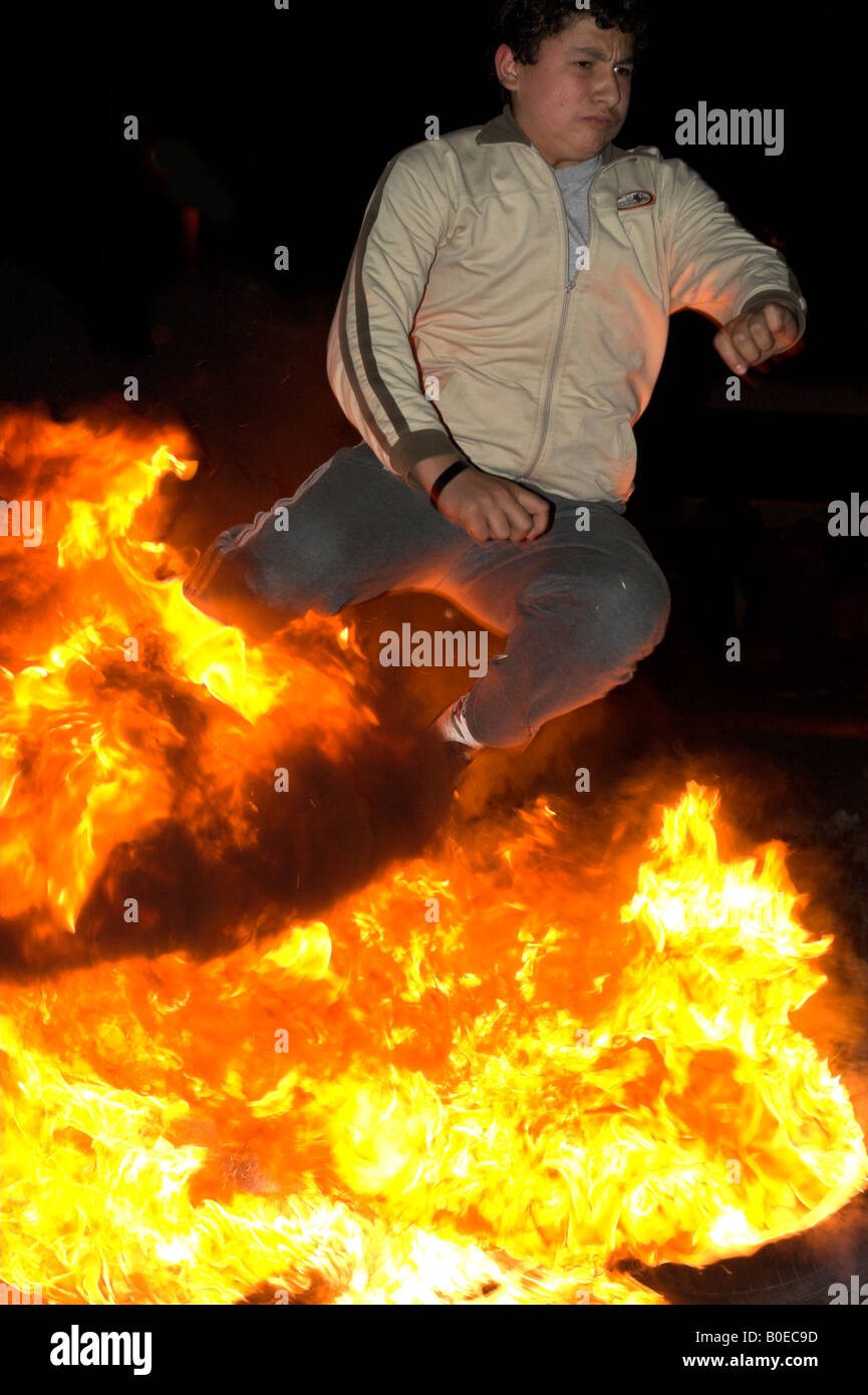 boy jumping over fire as a part of tradition during celebrations of the spring festive Hidrellez Stock Photo