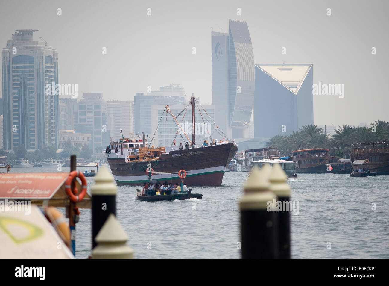 Dubai, United Arab Emirates (UAE). A dhow sails past modern office buildings along Dubai creek, which divides the city Stock Photo