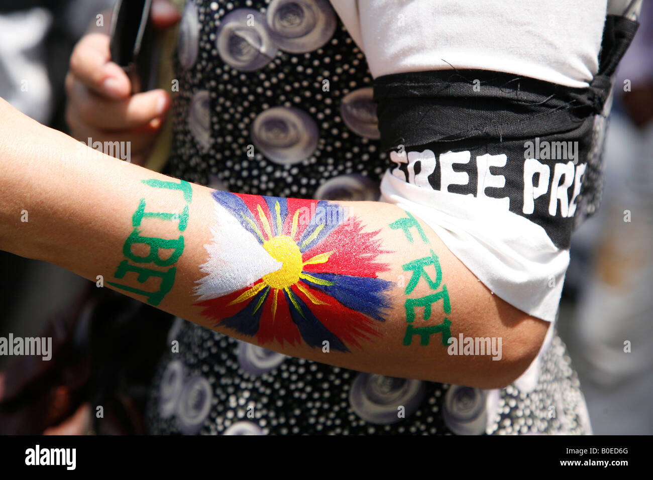 A protester at Janpath New Delhi has a Tibetan flag and a Free Tibet slogan on her arm. Stock Photo