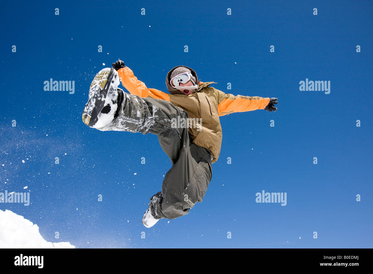 Man leaps from snowy jump. Stock Photo