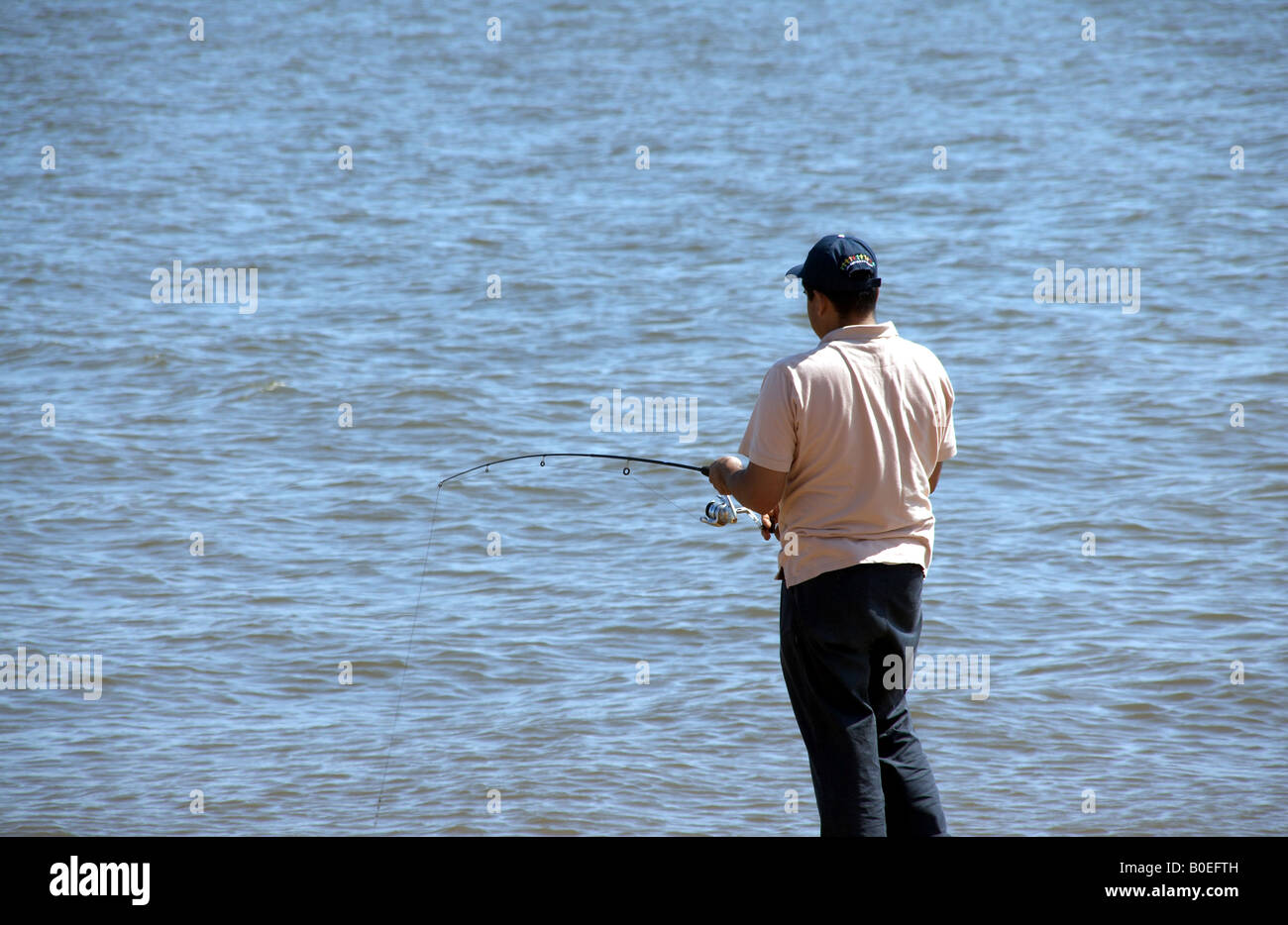 Hispanic man fishing in the Chesapeake Bay Stock Photo
