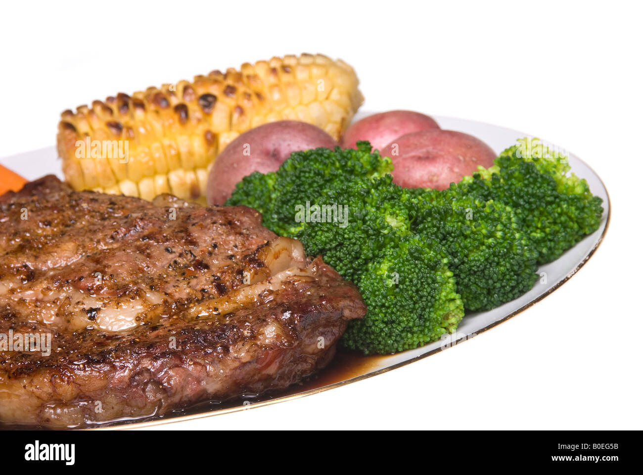 A delicious steak dinner consisting of a filet baby carrots broccoli baby potatoes and corn on the cob Stock Photo