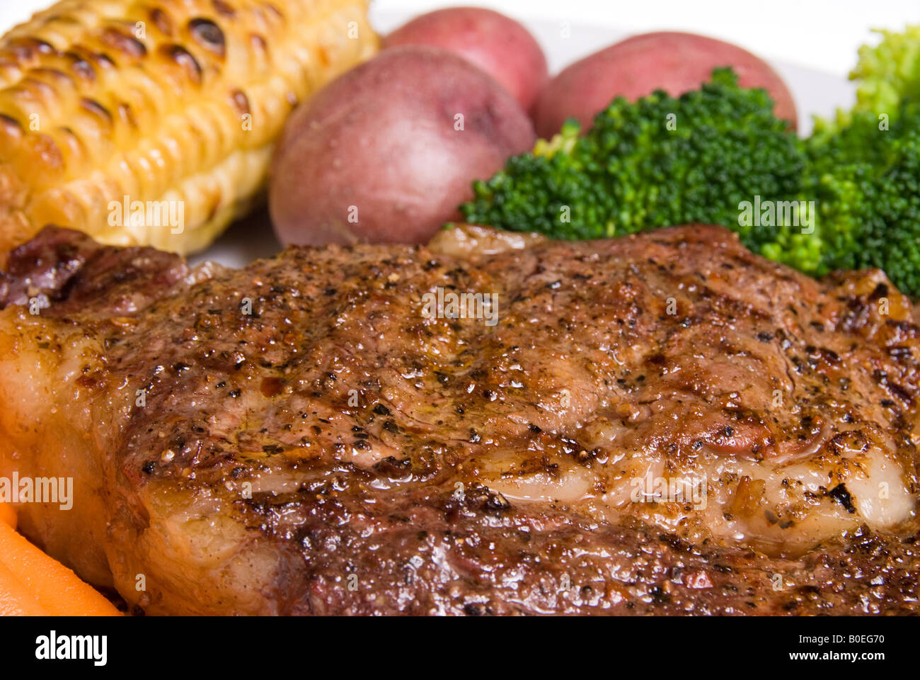 A delicious steak dinner consisting of a filet baby carrots broccoli baby potatoes and corn on the cob Stock Photo