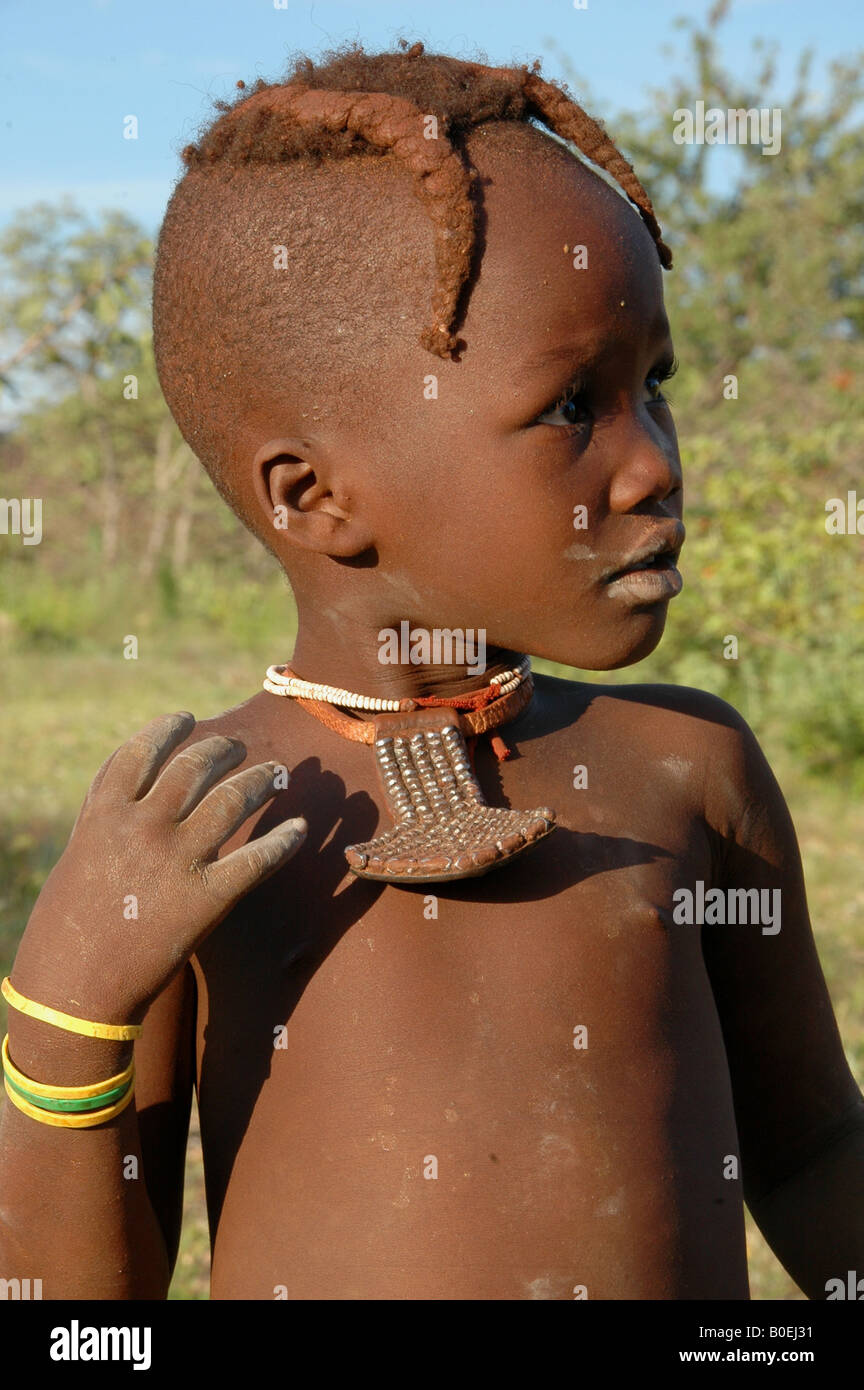 Young Himba girl showing traditional hairstyle and bracelets in Kaokoland, Namibia, Africa Stock Photo