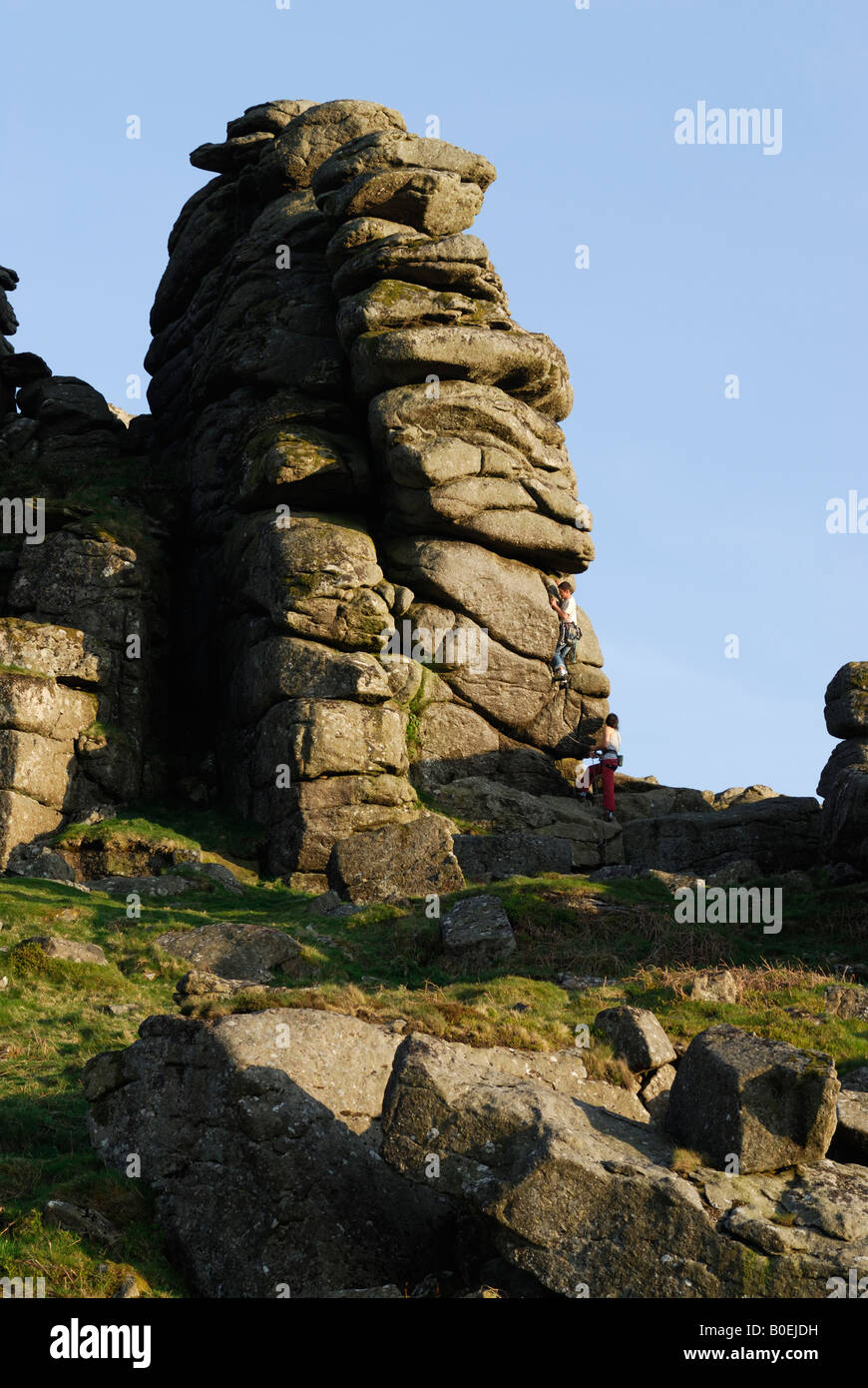 Climbers on granite stack at Hound Tor, Dartmoor, Devon, UK Stock Photo