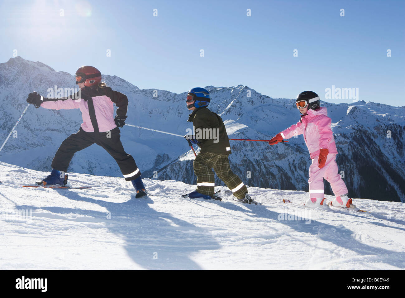 Children walking up slope with skis on Stock Photo