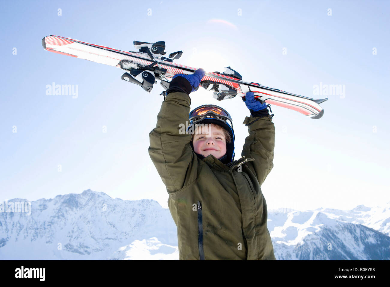 Boy holding skis above his head Stock Photo - Alamy