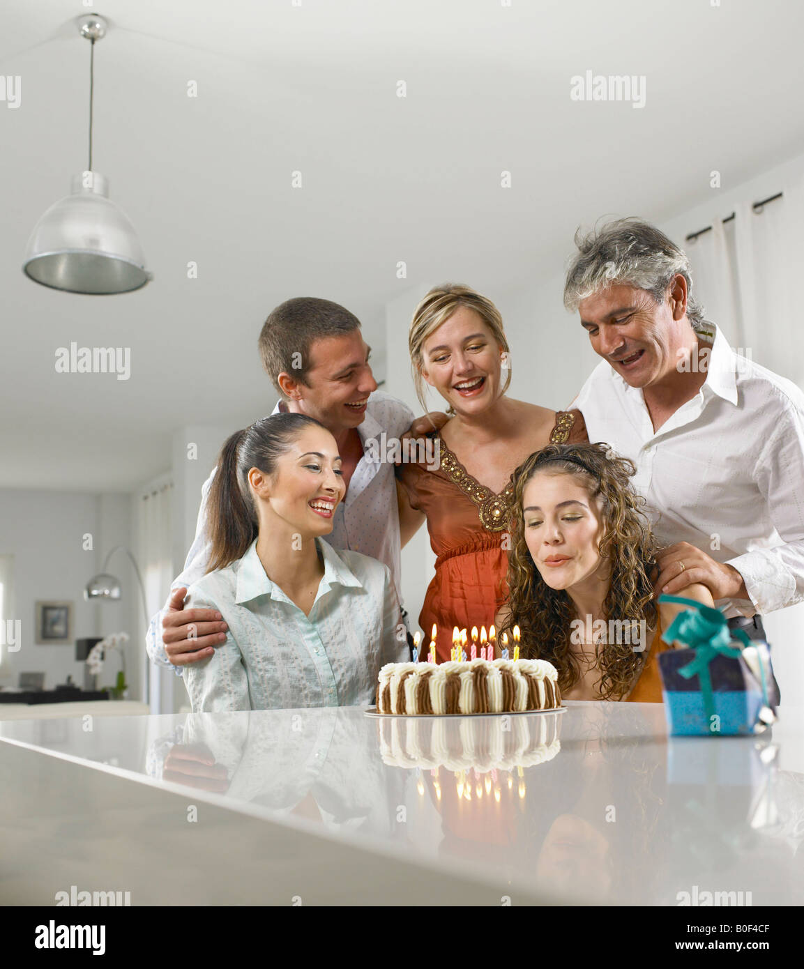 Family sitting around a birthday cake Stock Photo