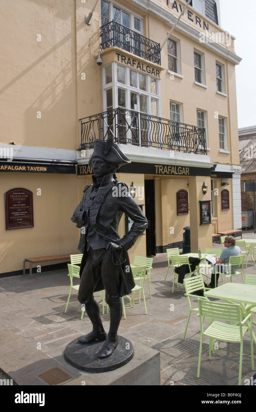 Statue of Admiral Nelson outside the Trafalgar Tavern Greenwich, Man sits and reads and drinks Stock Photo