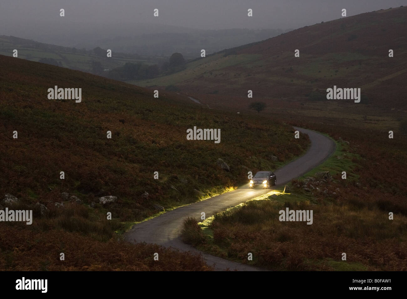 Mercedes car drives along a country road at night Dartmoor Devon United Kingdom Stock Photo