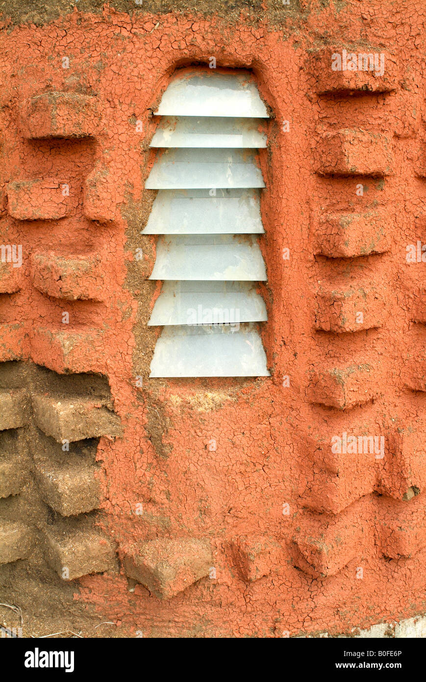 The window of a home made of natural materials in Asia - brick, rice husks and natural dyes. Stock Photo