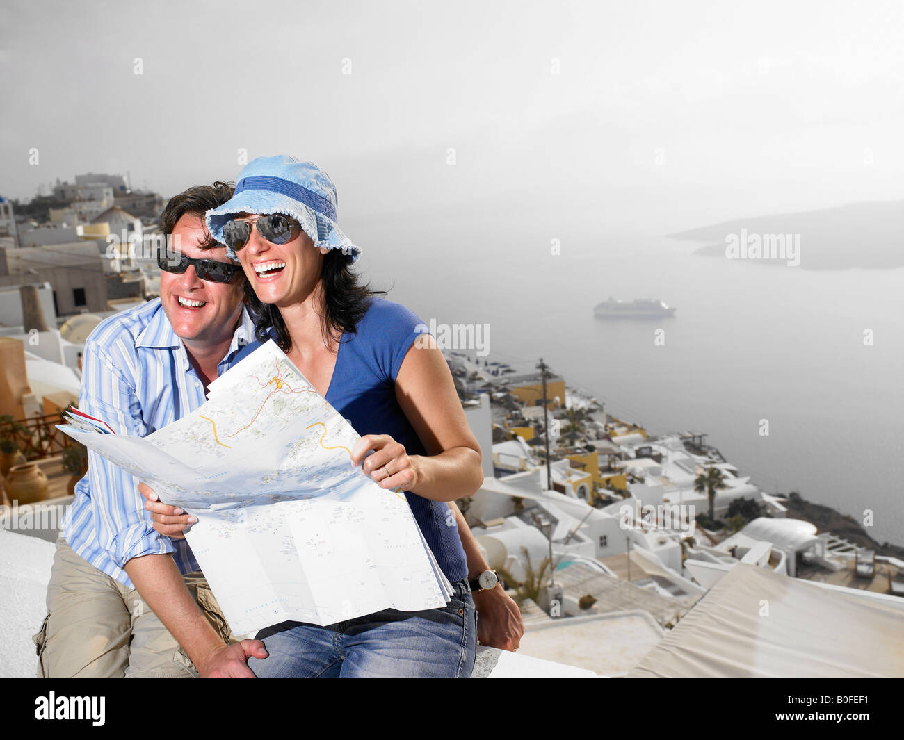 Couple looking at a map, laughing Stock Photo