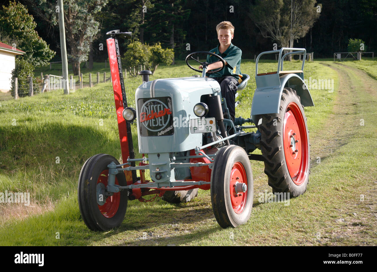 Antique 1956 Eicher 1 cylinder tractor with youth driver. model released Stock Photo