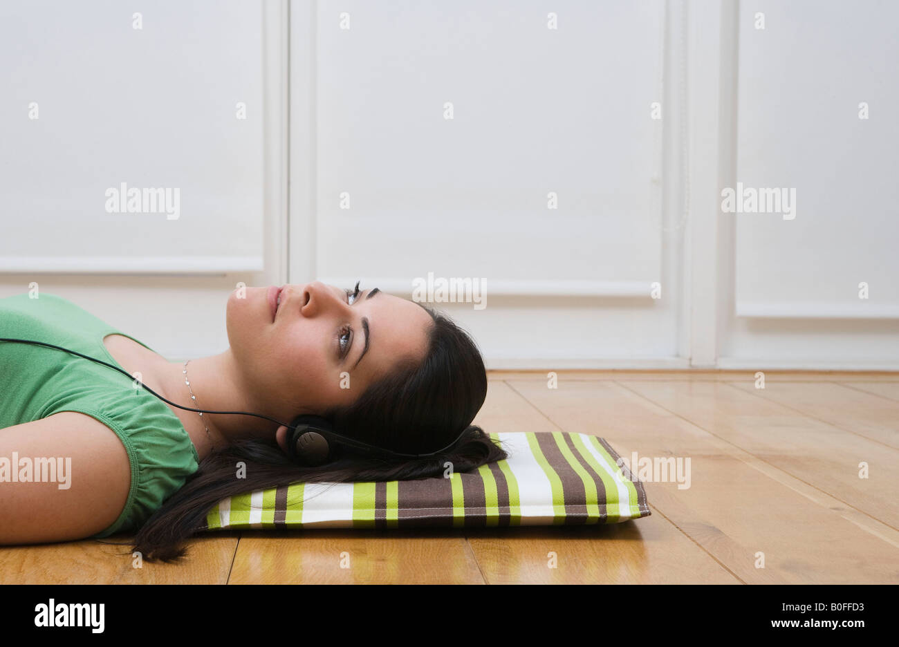 Woman lying on floor listening to music Stock Photo - Alamy