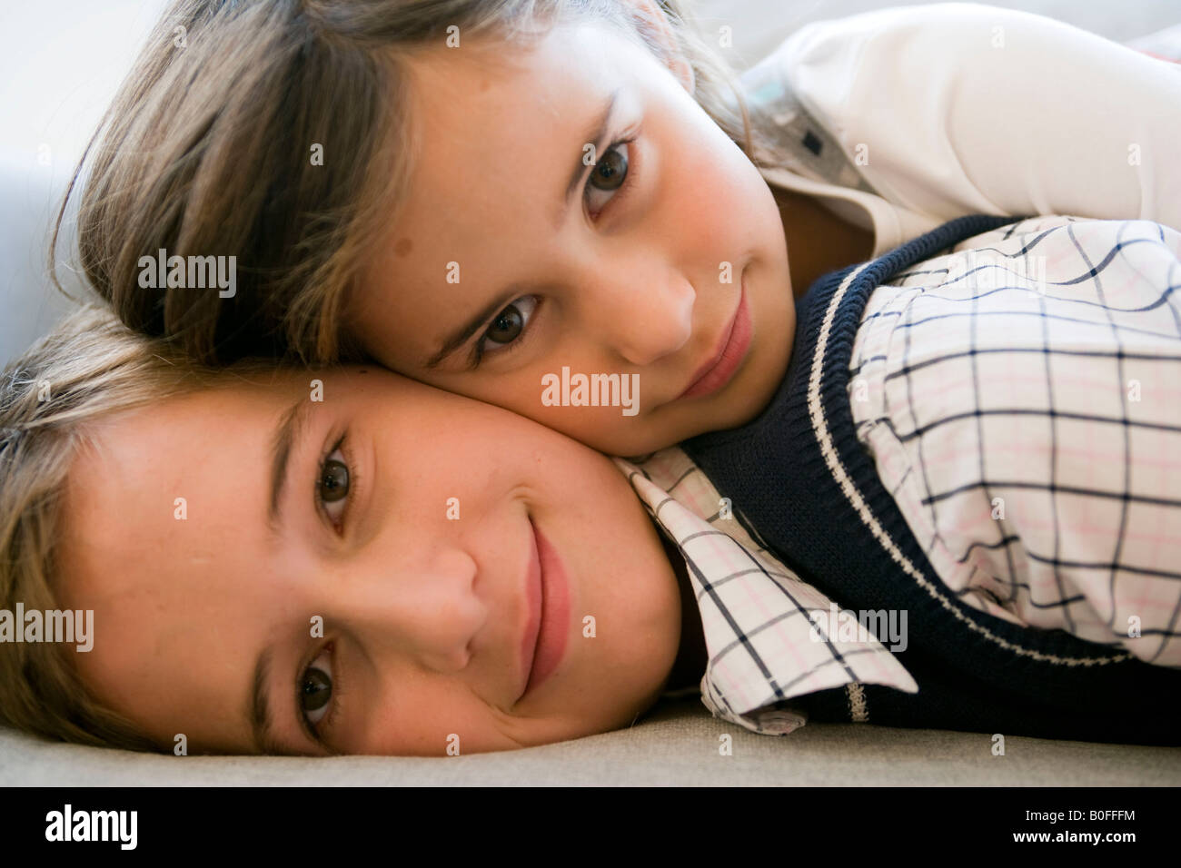 brother and sister lying on sofa Stock Photo