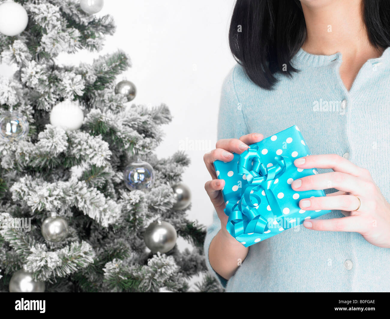 Woman next to a fir-tree, with present Stock Photo