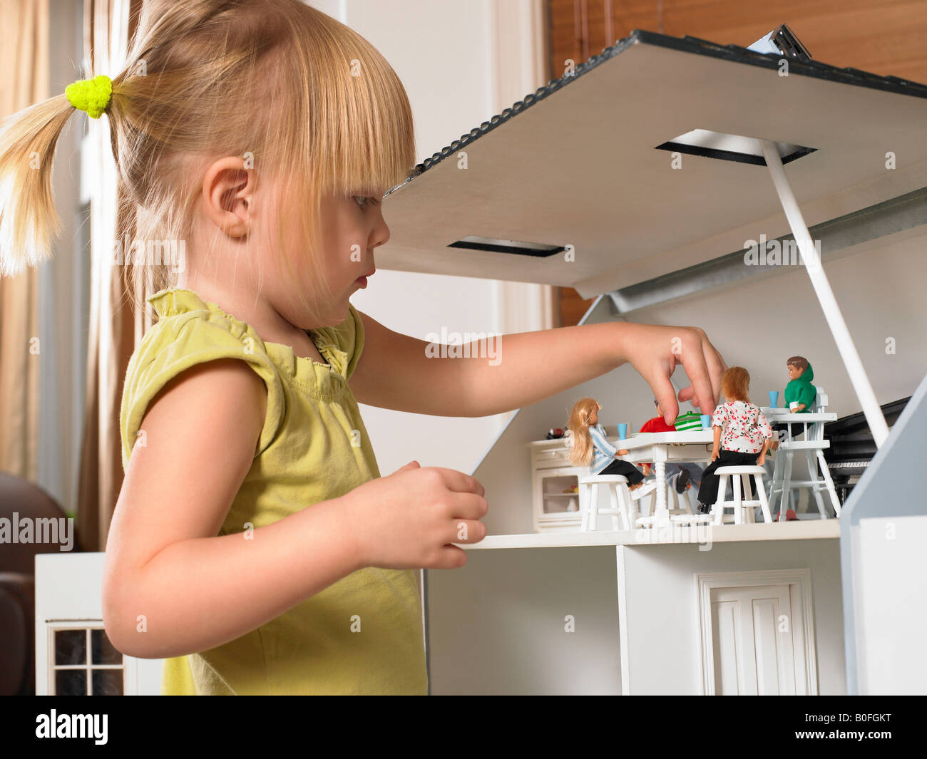 Little girl playing with a doll house Stock Photo - Alamy
