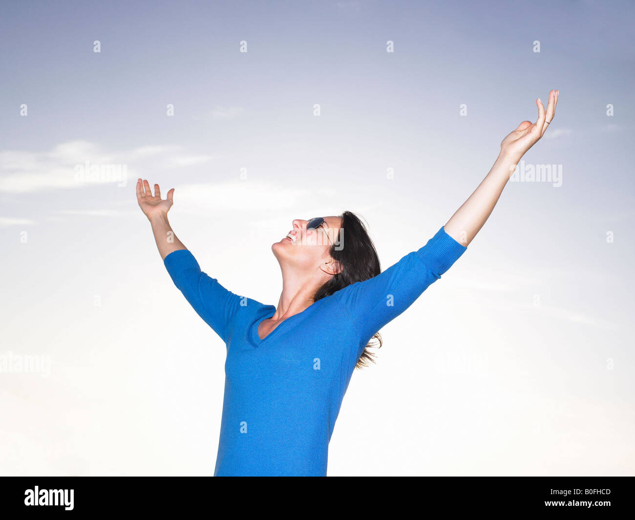 Woman stretching her arms, blue sky Stock Photo - Alamy