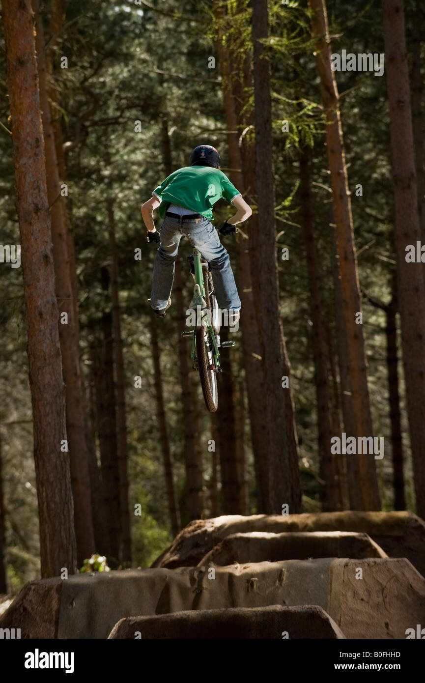 mountain bike dirt jump trick stunt air leap bmx mountain bikes MTB  BMX dirt jumper pulls stunts in trees sick whip youth sport Stock Photo