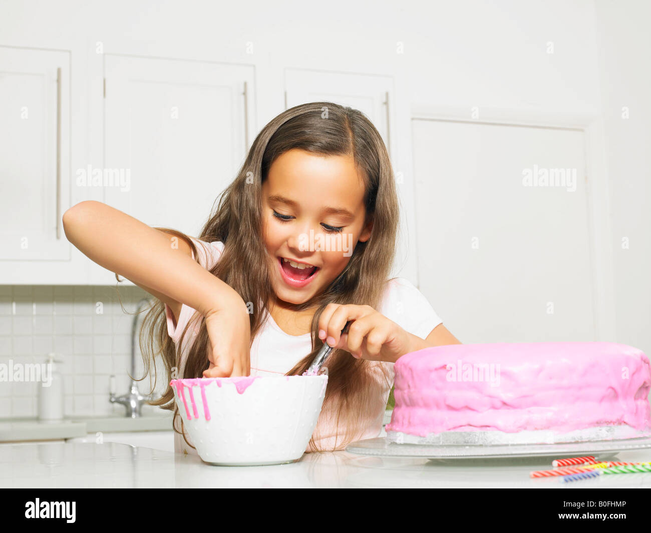 Girl (810) dipping finger in icing bowl Stock Photo Alamy