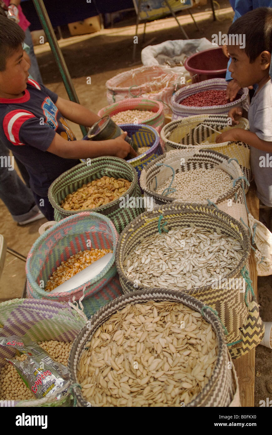Colorful baskets of beans and grains with two children learning the trade. Market in Baja California Norte, Mexico Stock Photo