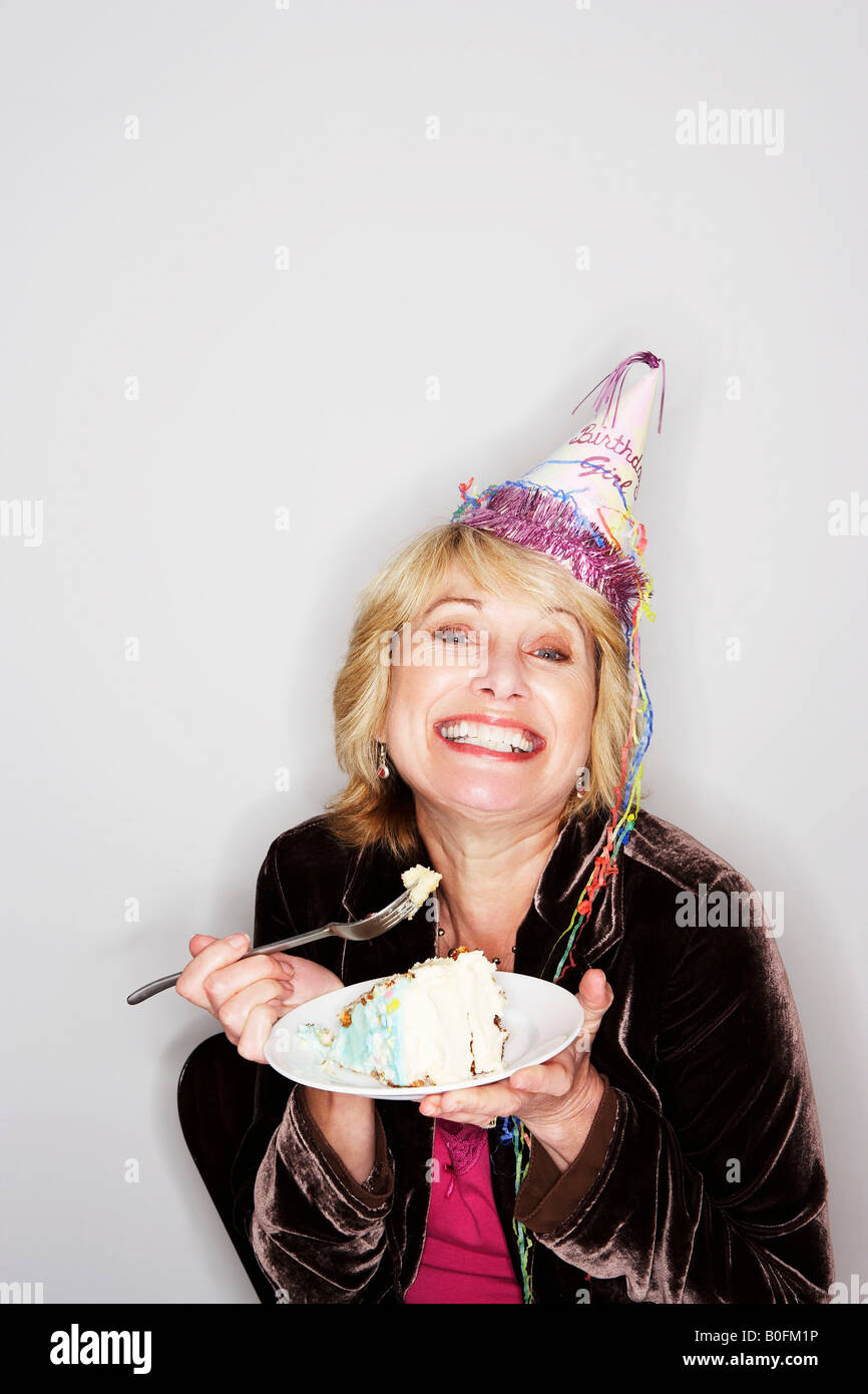 Senior woman eating birthday cake Stock Photo
