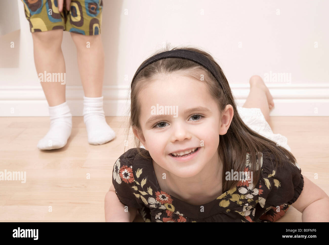 Girl on floor girl standing behind Stock Photo