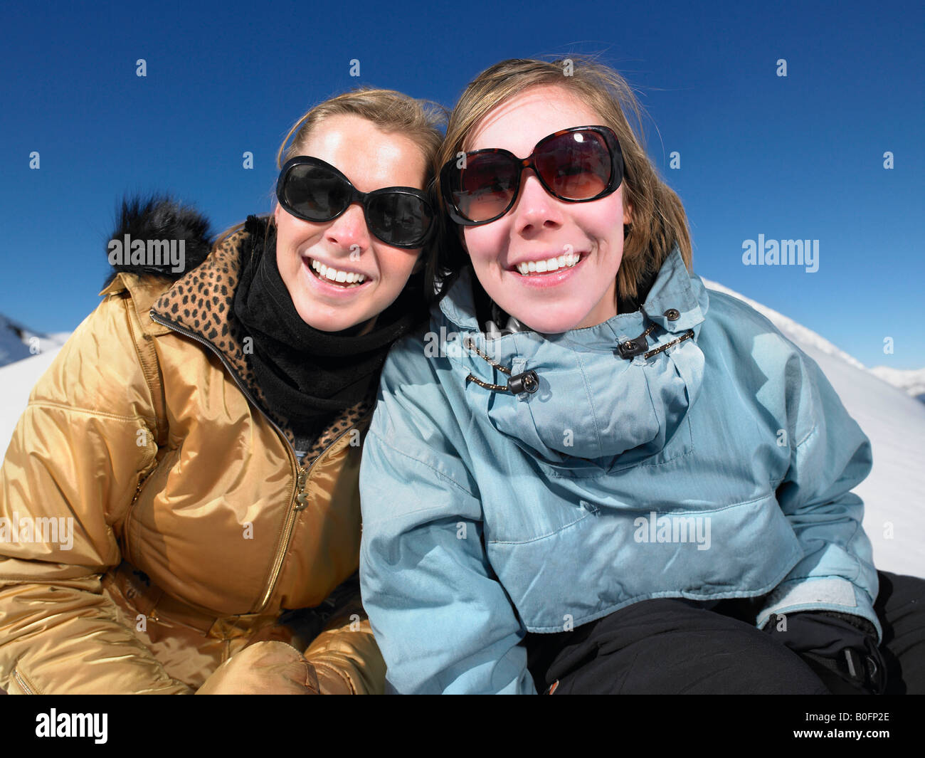 Smiling young women in snow Stock Photo - Alamy